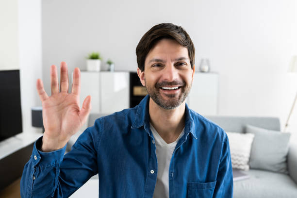 istock Happy Man Portrait Waving To Webcam 1316936520