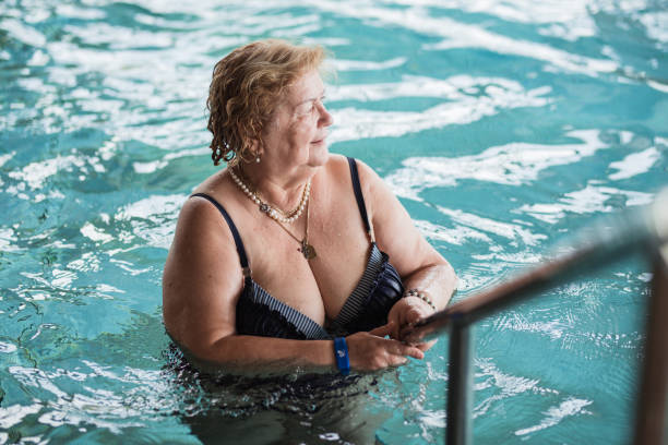istock Cheerful senior woman exiting swimming pool 1316936598