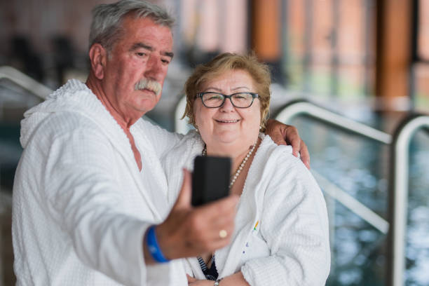 glückliches senior-paar macht selfie auf schwimmbad - overweight smiling senior women 70s stock-fotos und bilder