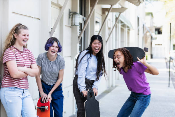 istock Four tween girls hang out on sidewalk with skateboards 1316937546