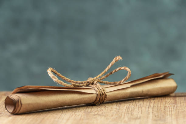 istock Craft paper is rolled into scroll and tied with old rope. 1316937596