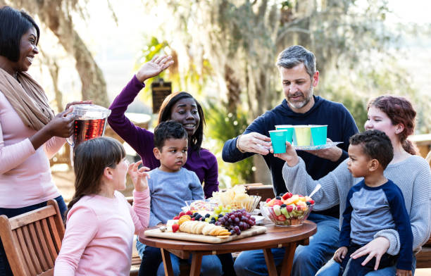 famiglia mescolata con cinque bambini che fanno un picnic - picnic family barbecue social gathering foto e immagini stock