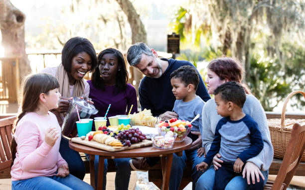 famiglia mescolata con cinque bambini che fanno un picnic - picnic family barbecue social gathering foto e immagini stock