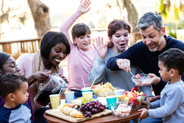 famiglia mescolata con cinque bambini che fanno un picnic - picnic family barbecue social gathering foto e immagini stock
