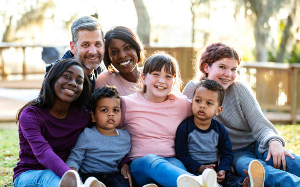 istock Blended family with five children sitting in park 1316938968