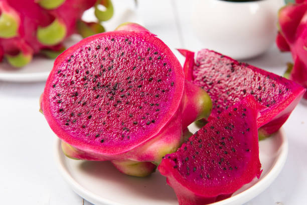 istock red pitaya with half isolated on white wood background 1316940313