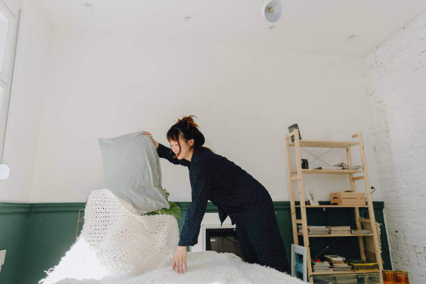 istock Young woman making bed after waking up 1316953069