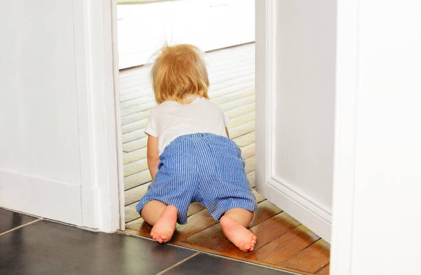 Little toddler boy crawl to the room with view from behind