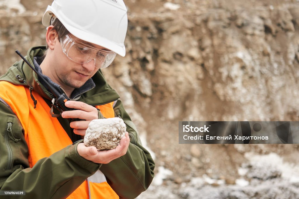 geologist examines a mineral sample man geologist examines a mineral sample Geology Stock Photo