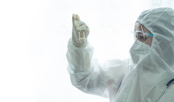 istock doctor with PPE holding covid 19 vaccine bottle 1316964196