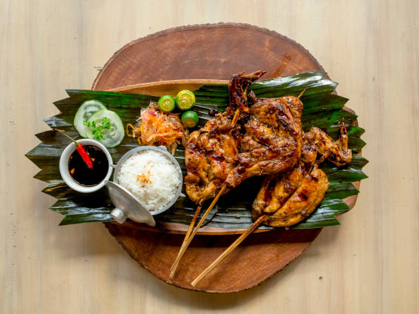 Top view of juicy Chicken Inato with a serving of garlic rice and atchara. Placed on a circular wooden tray. A popular grilled dish in Cebu. Top view of juicy Chicken Inato with a serving of garlic rice and atchara. Placed on a circular wooden tray. A popular grilled dish in Cebu. philippines stock pictures, royalty-free photos & images