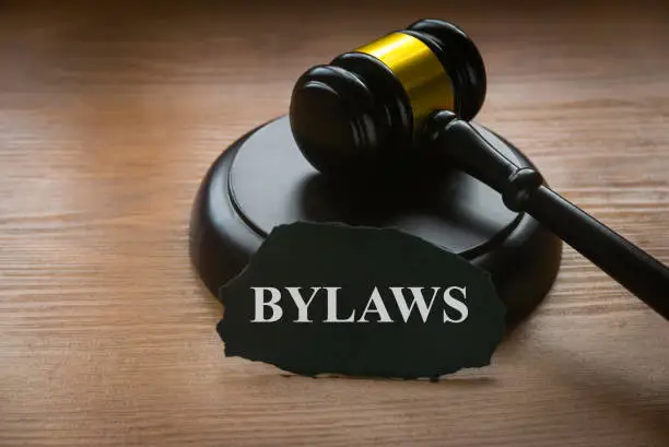 Bylaws phrase with gavel on wooden background. Business and law concept