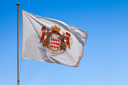 Flag of Monaco waving atop of its pole.