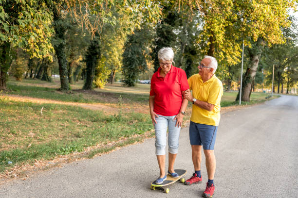 istock Active senior couple enjoying day together while riding skateboard in the park 1316971365