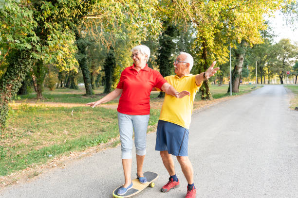 istock Active senior couple enjoying day together while riding skateboard in the park 1316971379