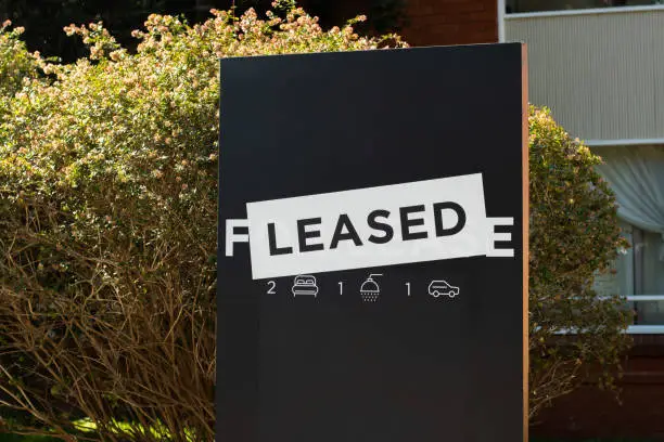 For lease and leased sign on a black .display outside of a resedential building
