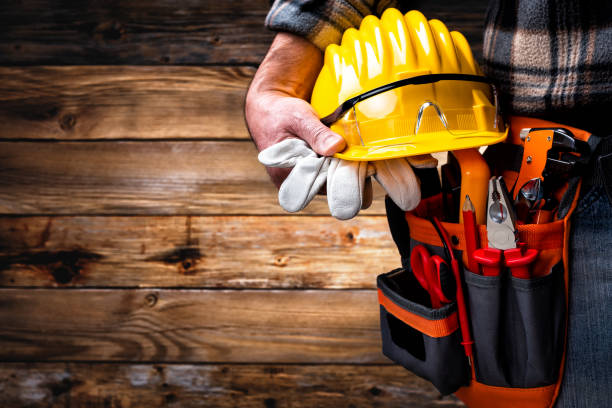 Electrician technician with tool belt on rustic wooden background. Electricity.