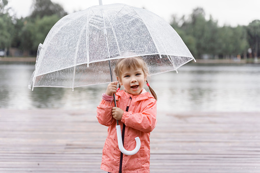 Outdoor portrait of a cute child girl under umbrella