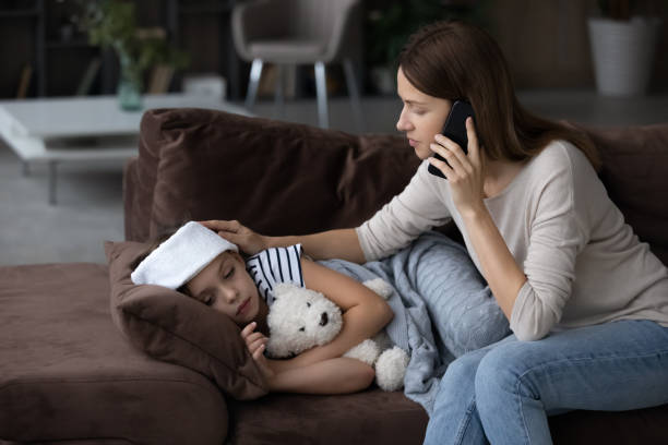 Caring mom call ambulance for sick small daughter Anxious young Caucasian mom call ambulance doctor take care of sick small girl child having flu and high temperature. Worried mother contact therapist or pediatrician with little daughter feel ill. fever stock pictures, royalty-free photos & images