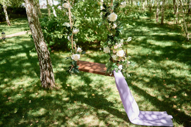 istock Wedding swing decorated with rose flowers hanging on tree in garden, copy space 1316979491