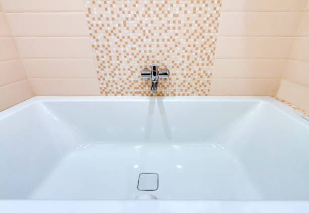 istock White modern bathtub with faucet yellow pattern tile wall background 1316980766