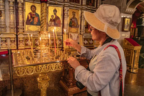 Mature woman lights a candle in theChurch on Blood in Yekaterinburg,Sverdlovsk Region,Ural,Russia,Nikon D850