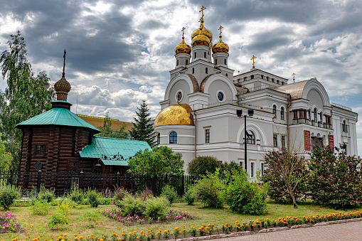 Beautiful yellow and gold domes of the Orthodox Church against the background of the blue sky and the city. Domes of the Assumption Cathedral of the Kiev-Pechersk Lavra.