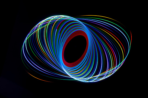 Colorful abstract waves of light and black background, produced with pendular movement
