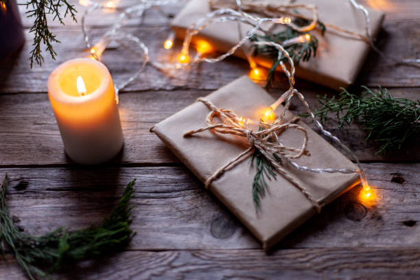 istock Gift packages wrapped in craft paper, a candle and small light bulbs. 1316986125