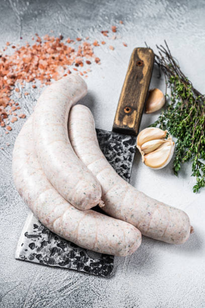 Bavarian traditional white sausages on a meat cleaver. White background. Top view Bavarian traditional white sausages on a meat cleaver. White background. Top view. weisswurst photos stock pictures, royalty-free photos & images