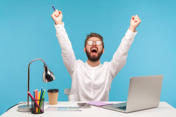 istock Very excited man with beard office worker screaming eureka raising hands up, solving hard task, getting access, successfully completing work 1316986734
