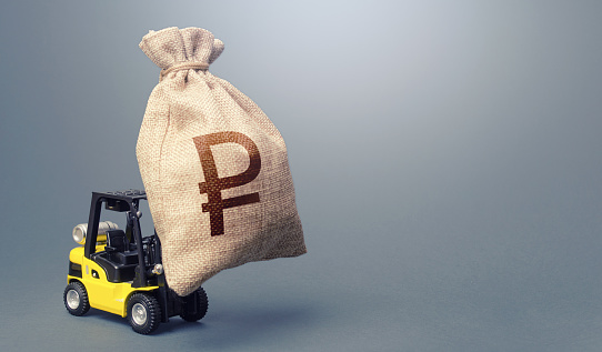 Forklift carrying a russian ruble money bag. Strongest financial assistance, business support. Anti-crisis budget. Borrowing on capital market. Stimulating economy. Subsidies soft loans. Investments.