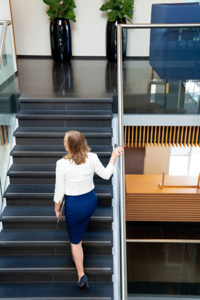 istock Career woman walking up stairs 1316991204