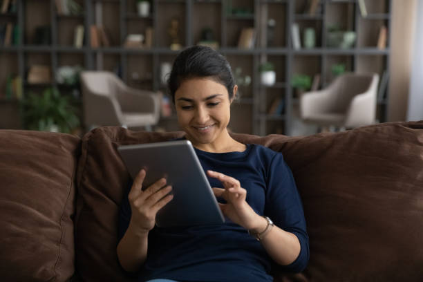 istock Happy Indian woman use tablet texting online 1316991400