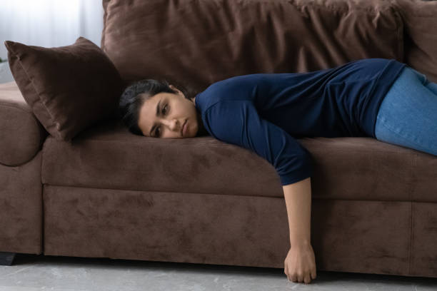 istock Tired Indian woman lying on sofa feeling lazy 1316991489