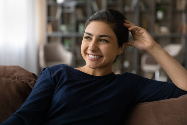 istock Smiling Indian woman relax at home dreaming 1316991490