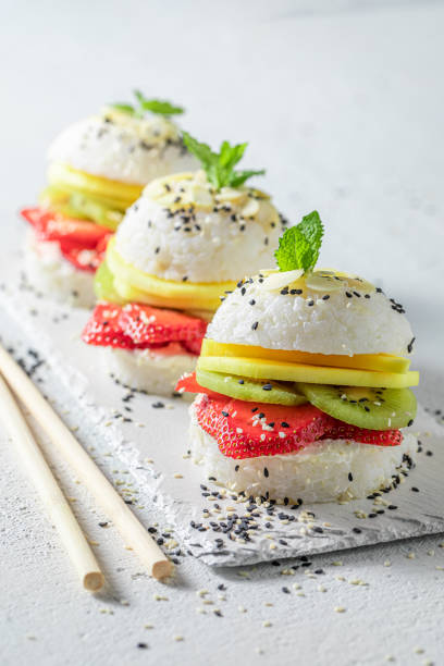istock Sweet sush burger with mango and strawberries on stone plate. 1316994793