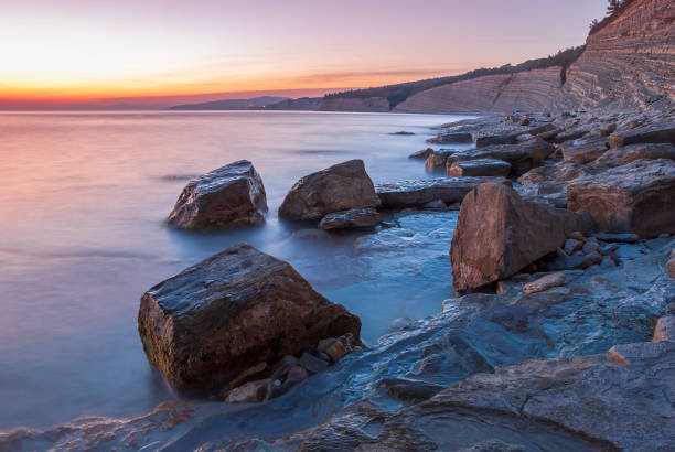 istock Seascape at sunset. Sea on a long shutter with stones and rocks. 1316995596
