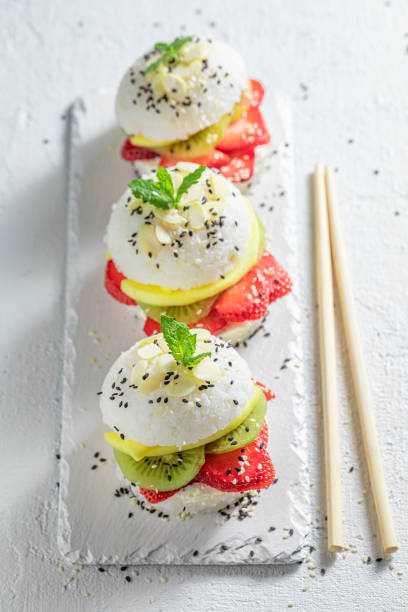 istock Exquisite sush burger with mango and strawberries on stone plate. 1316995768
