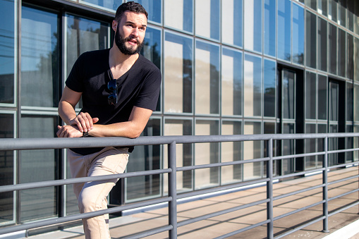 Photo of a young man in front of a office building.