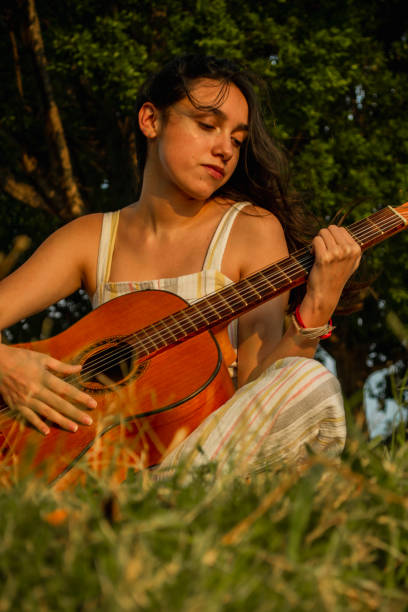 istock Sitting woman looking at the guitar on her hands 1317002744