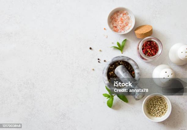 Seasonings White Black And Pink Peppers Pink Salt And Shaker On Gray Stone Background Stock Photo - Download Image Now
