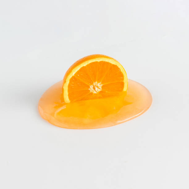 Creative summer idea with half orange fruit melting on a white background. Healthy diet or nature concept. Organic tropical fruit juice.