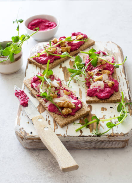istock Open face sandwiches with beetroot hummus, walnuts, parmesan cheese  sesame seeds and micro  greens 1317004709