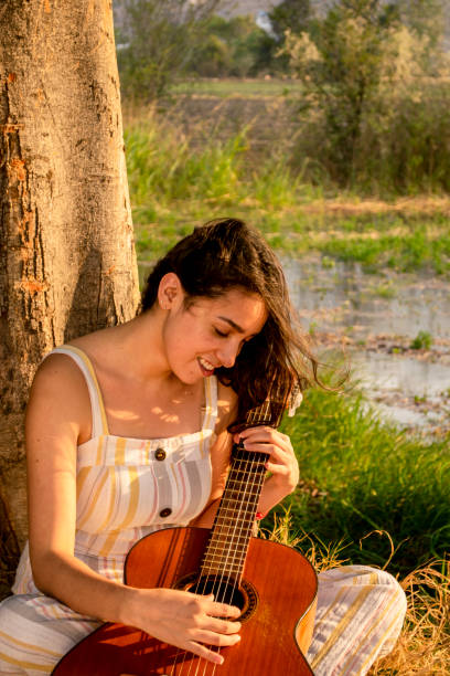 istock Sitting woman looking her guitar 1317005586