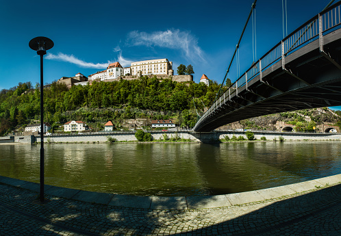 Passau, Bavaria, Germany. The Veste Oberhaus and the Danube river in the foreground. The Luitpold Bridge is a suspension bridge and road bridge that was completed in 1910.