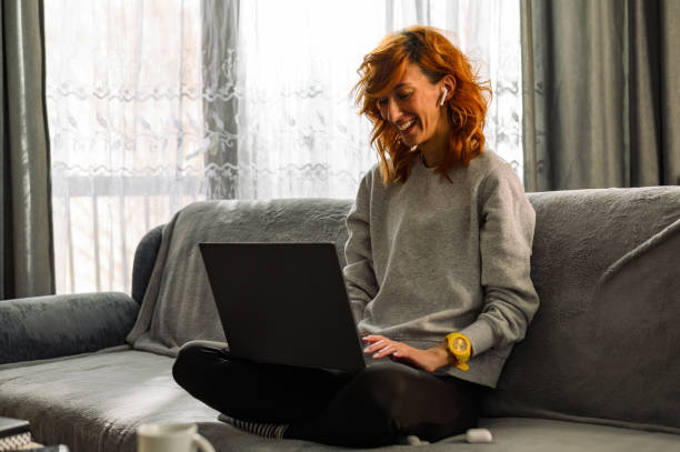 istock Young redhead woman using laptop at home 1317007198