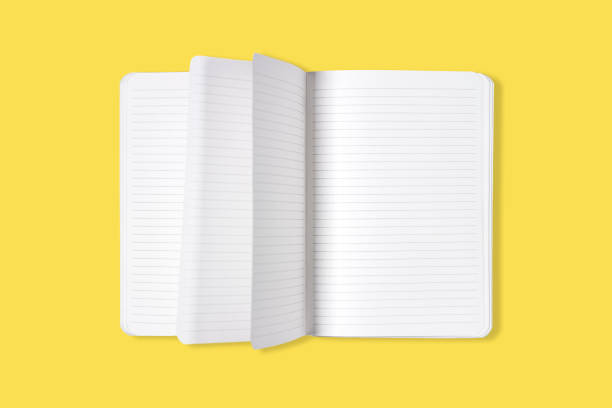istock Blank open office Notepad or notebook with flipping pages isolated on yellow background. Mock up. Top view. 1317008303