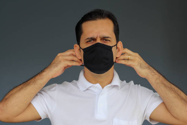 istock Man putting on (or taking off) his viral protection mask 1317012035