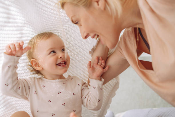 istock Cute blond girl playing with mother under blanket 1317017354